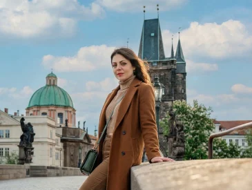 A stylish woman walking on cobblestones in Prague